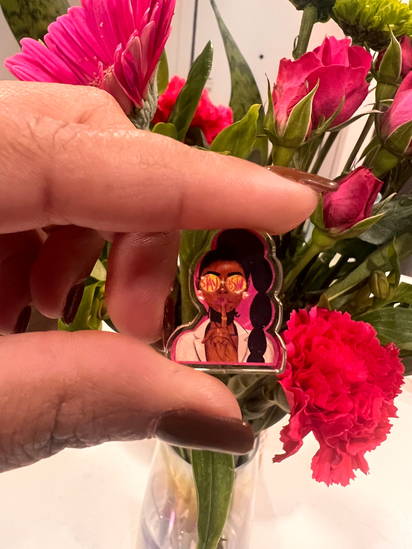 A stylish and empowering acrylic pin featuring the intricate illustration of a confident Black woman. The design showcases cultural pride, beauty, and strength, with rich details in hair, attire, and expression, making it a statement accessory for self-expression and celebration of diversity